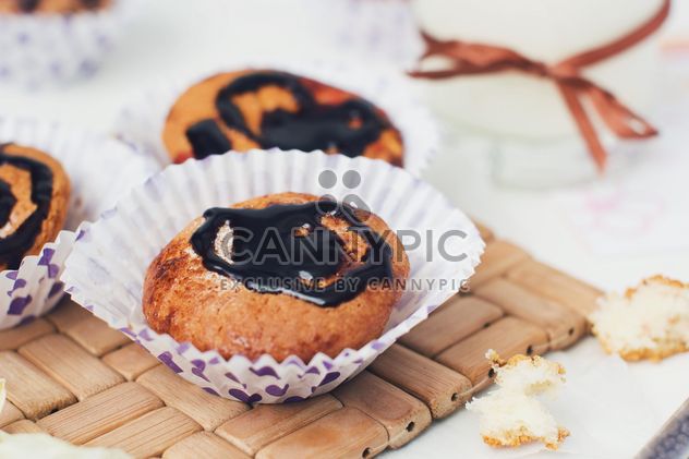 Cupcakes with chocolate on table - image #182733 gratis