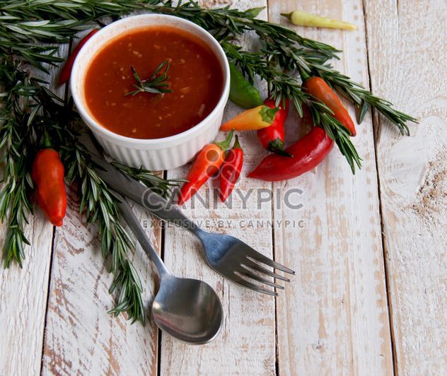 tomato sauce with rosemary and chili peppers on a wooden table - Free image #183363