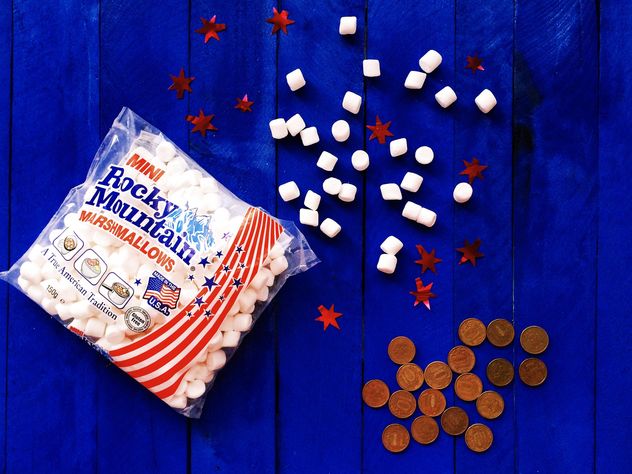 American marshmallows and coins on blue wooden background - Kostenloses image #183833