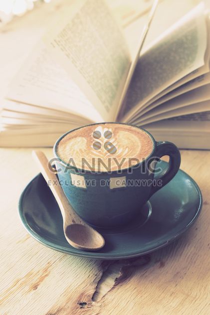 Coffee latte art and open book on wooden table - бесплатный image #187073
