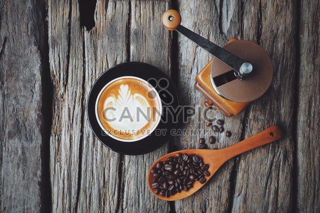 Latte art, coffee grinder and spoon with coffee beans on wooden background - бесплатный image #187093