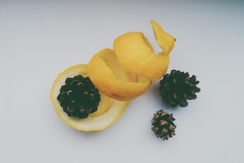Lemon peel and pine cones over white background - image gratuit #272213 