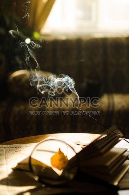 Autumn yellow leaves through a magnifying glass and incense sticks and book - бесплатный image #330403