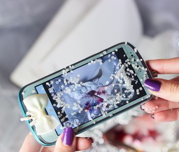 Smartphone decorated with tinsel in woman hands - бесплатный image #342193