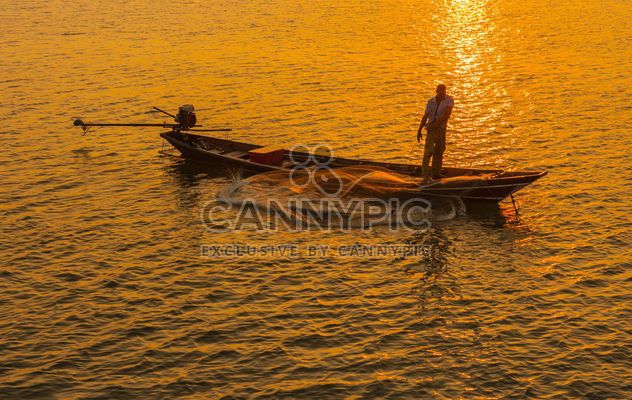 Fisherman in boat on sea at sunset - image gratuit #344623 