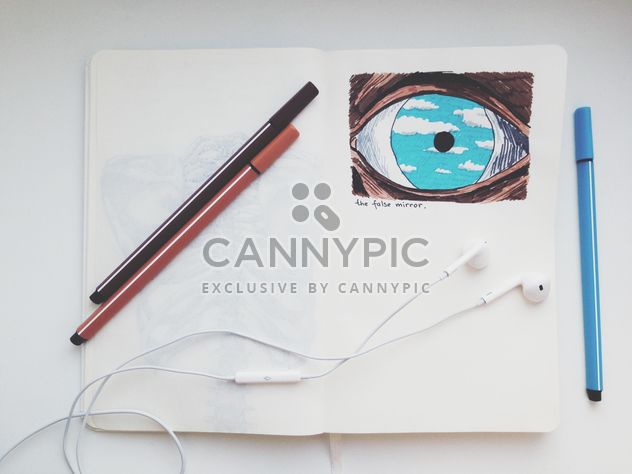 Earphones and markers on notebook with picture - image gratuit #346563 