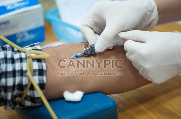 Doctor drawing blood from patient with syringe - Free image #347253