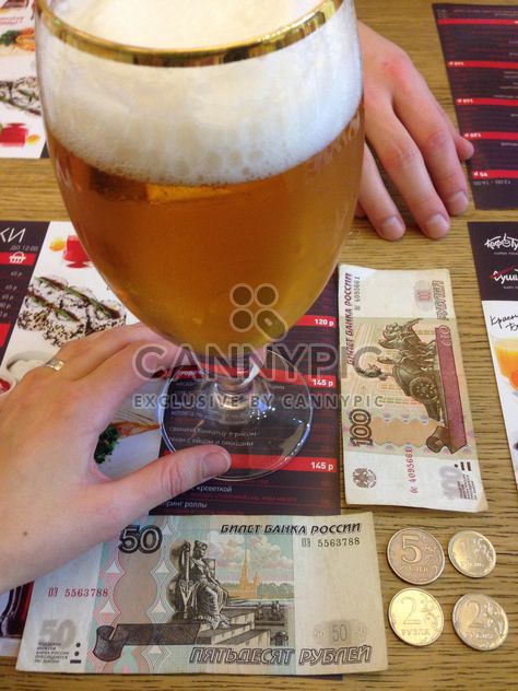 Glass of beer and money on table in cafe - Free image #347933