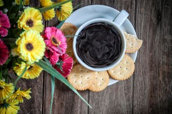 Cookies, cup of coffee and flowers on wooden background - бесплатный image #452413