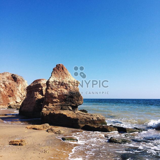 Rocks in sea under blue sky - image #136213 gratis