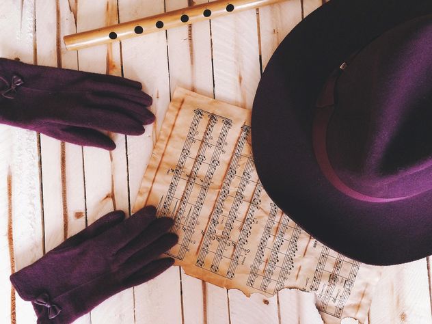Purple gloves, hat, notes and pipe over wooden background - image #136273 gratis