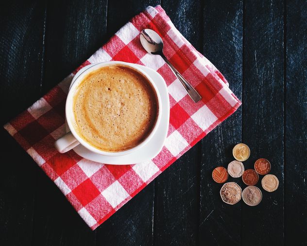 Cup of coffee, checkered dishcloth and coins - бесплатный image #136283