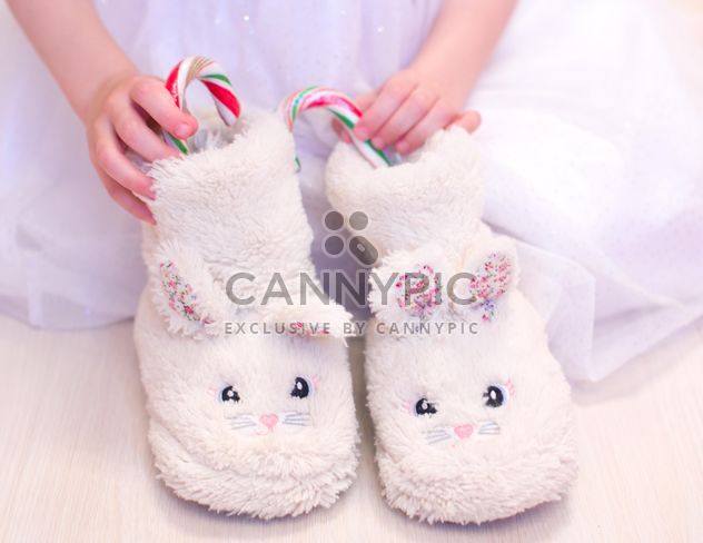 Warm slippers with candies in child's hands - Free image #182553