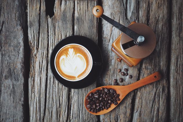 Latte art, coffee grinder and spoon with coffee beans on wooden background - Kostenloses image #187093