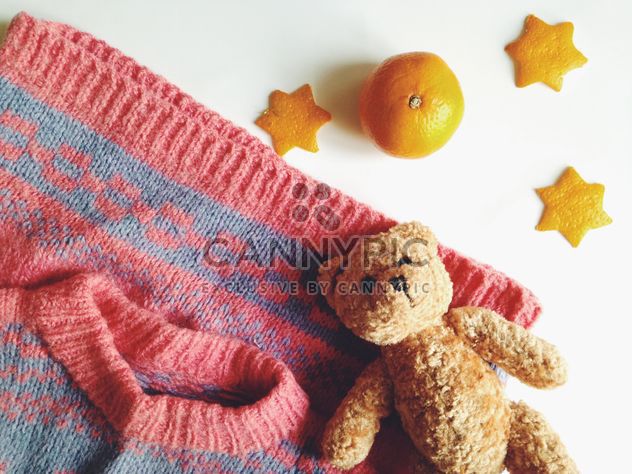 Children's sweater and a toy bear, tangerines on a white background - бесплатный image #198783