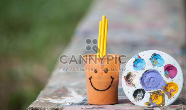 Palette with paints and cup with paintbrashes - Free image #200163
