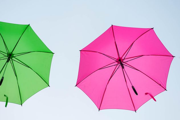 Green and pink umbrellas hanging - image #273063 gratis