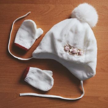 Warm childish hat and mittens on wooden background - image #301353 gratis
