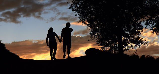 A couple walking in sunset silhouette. - бесплатный image #318743