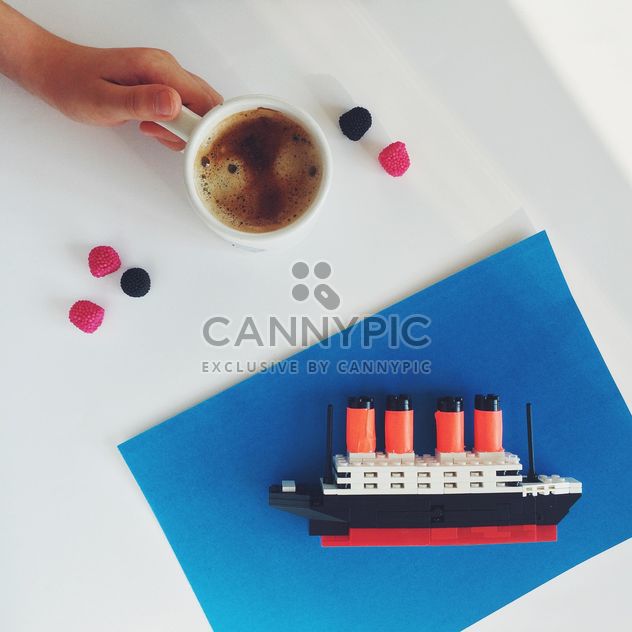 Cup of coffee and toy ship on white abckground - бесплатный image #329163