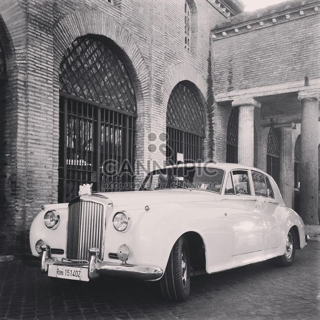 White Bentley near old brick building, black and white - image #331833 gratis