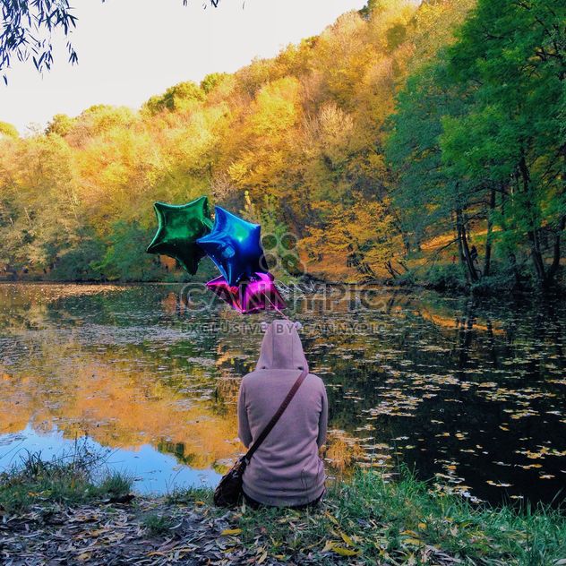 woman siiting on a river bank with colourful baloons - image gratuit #332833 