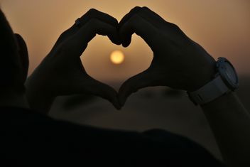 Hands in shape of heart at sunset - image #338513 gratis