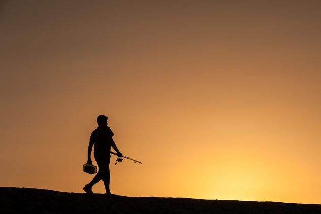 Silhouette of fisherman at sunset - Free image #338523