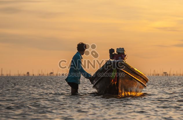 Fisherman with fishing boat at sunset - image #338573 gratis