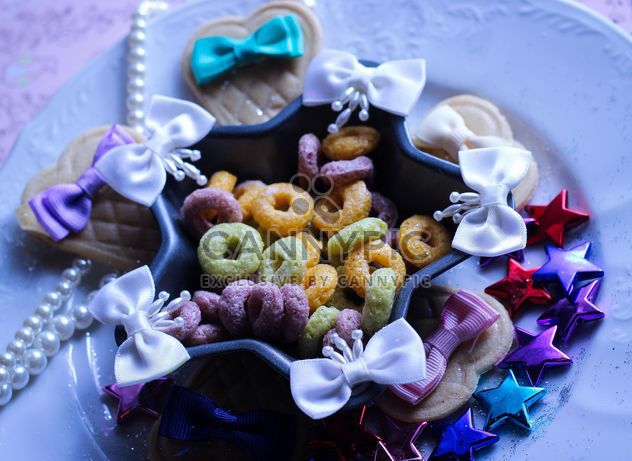 Decorative bows, tinsel and candies on the plate - бесплатный image #342073
