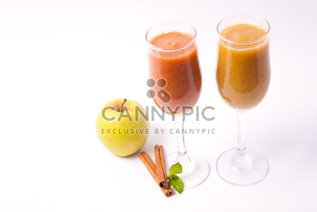 Citrus fresh juice in two glasses with cinnamon and apple - image #342503 gratis