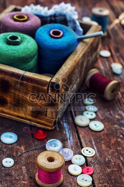 Colored buttons and sewing thread in wooden box on the table - Free image #342903