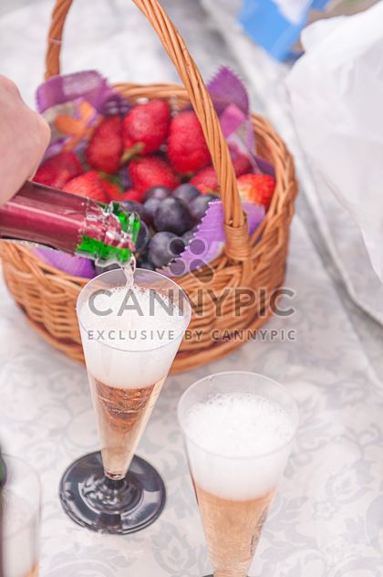 Two glasses of champagne and fruit in basket - image #345033 gratis