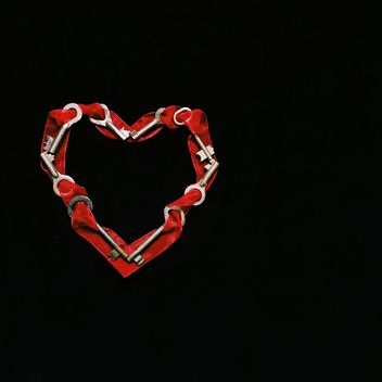 Heart made of keys and ribbons on black background - бесплатный image #345913