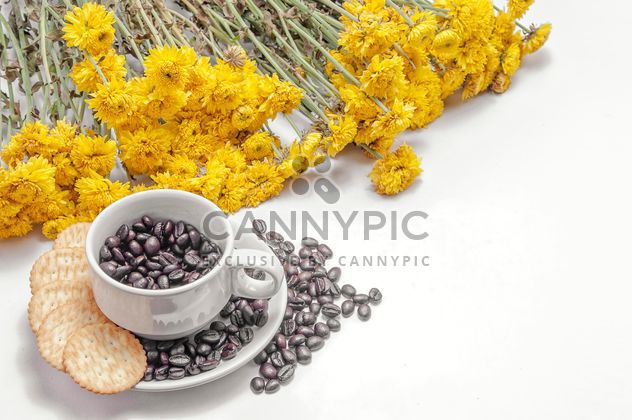 Cookies, cup of coffee beans and flowers over white background - бесплатный image #452433