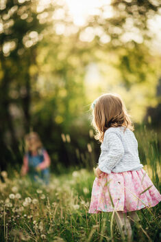 A little girl stands while at play in a meadow. - image #480343 gratis